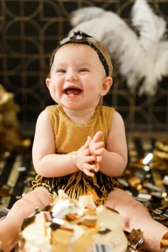 Enfant rieur devant un décor de charleston, doré et pailleté – séance photo joyeuse à Cergy.
