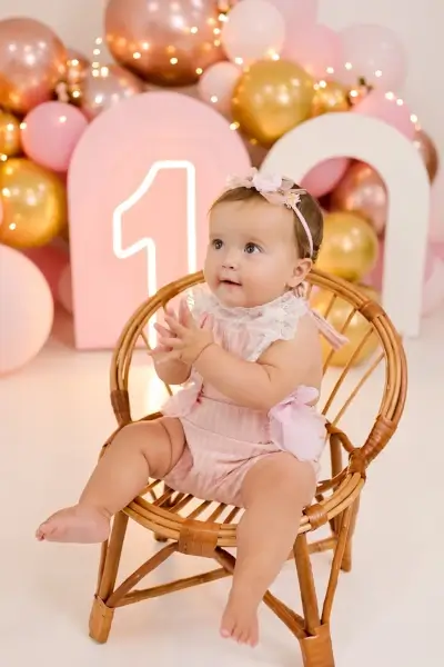 bébé sur une chaise en bois, célébration joyeuse d’un premier anniversaire en photo à Cergy.